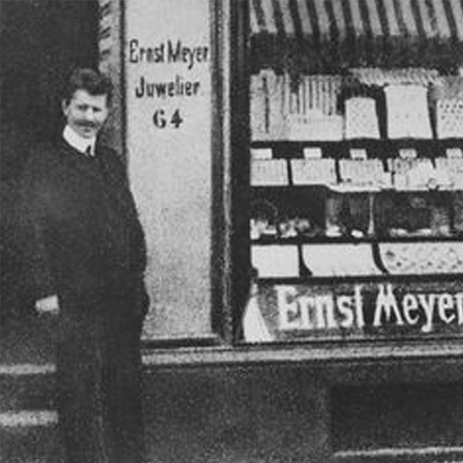 Altes Schwarz-Weiß-Foto des Schaufensters von Juwelier Ernst Meyer. Vor dem Eingang steht ein Mann.