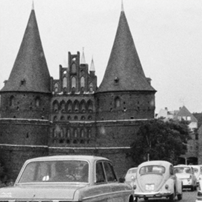 Altes Schwarz-Weiß-Foto vom Holstentor in Lübeck, wo Juwelier Mahlberg ein Geschäft hat