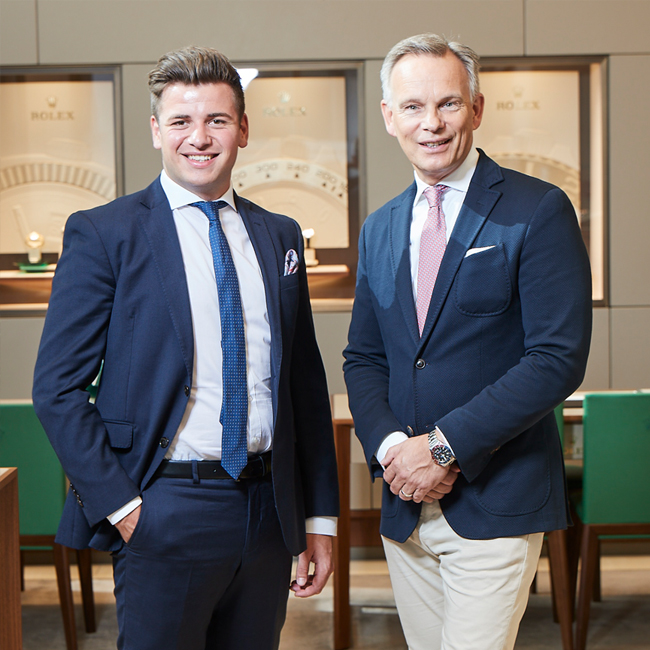 Foto von Uhrmachermeister Jens Söhnle und Verkaufsberater Eric von Petersdorff-Campen, die im Rolex Showroom stehen